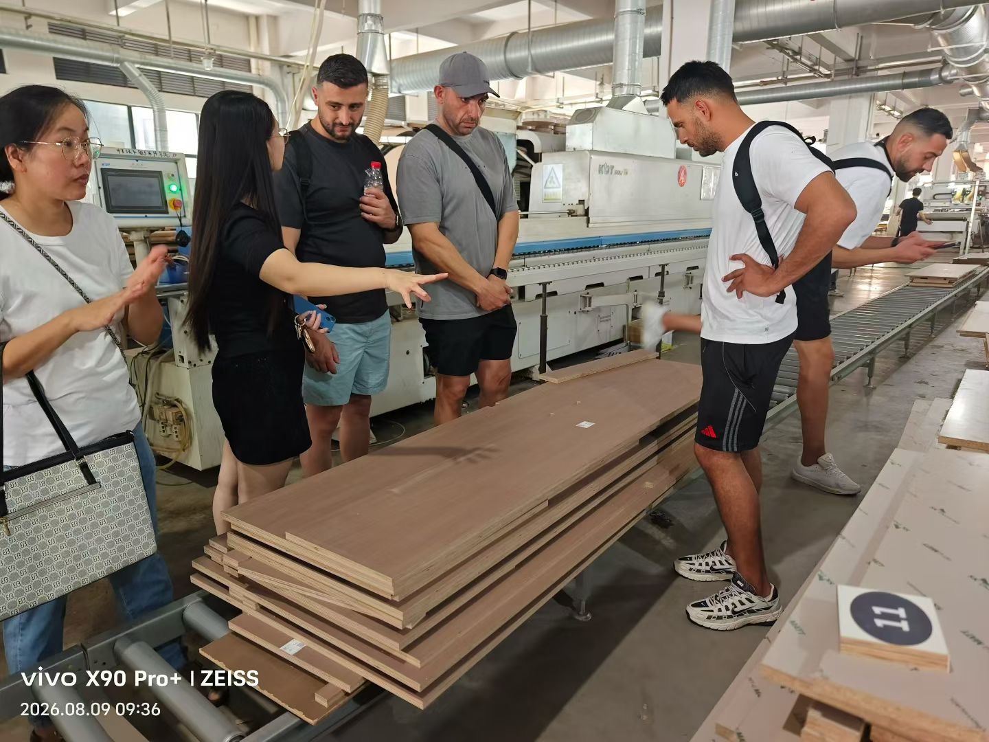 Inspecting veneered panel stock on the production line with factory staff
